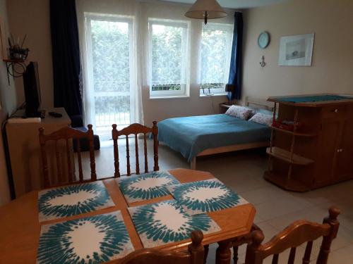 a living room with a table and a bed at Apartament Morskie Oko in Międzyzdroje