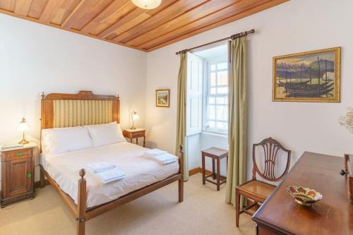 a bedroom with a bed and a table and a window at Quinta de Villa Franca - Douro in Peso da Régua