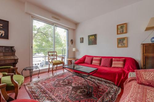- un salon avec un canapé rouge et une fenêtre dans l'établissement Port Royal Apart de Charme-Parking-Cœur de Ville, à Nantes