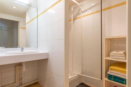 une salle de bain blanche avec un lavabo et un miroir dans l'établissement Port Royal Apart de Charme-Parking-Cœur de Ville, à Nantes