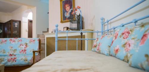 a bedroom with a bed with a blue frame and pillows at Woods Cottage Σπίτι με Τζάκι κοντά στα Λουτρά Πόζαρ in Megaplátanos