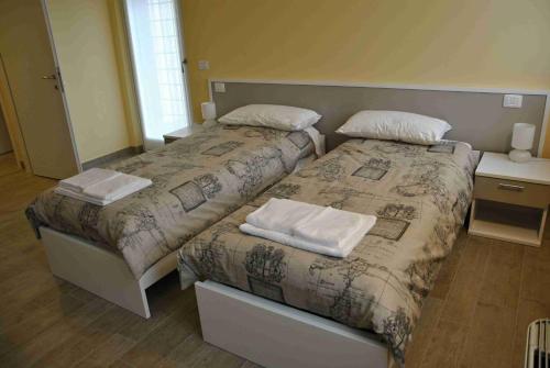 1 dormitorio con 2 camas y toallas. en B&B Francesca, en Verona