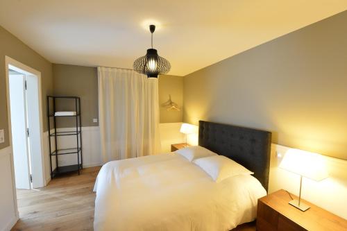 a bedroom with a white bed and two lamps at Gite Urbain Henri et Joseph in Lorient