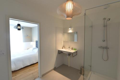 La salle de bains est pourvue d'une douche, d'un lavabo et d'un miroir. dans l'établissement Gite Urbain Henri et Joseph, à Lorient