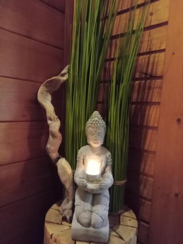 a statue holding a candle in a room with a plant at Apartment Serlesblick in Ellbögen