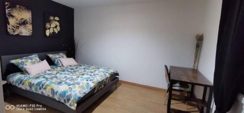 ein Schlafzimmer mit einem Bett, einem Tisch und einem Schreibtisch in der Unterkunft Appartement Cosy au cœur de la Champagne in Cramant