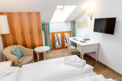 a hotel room with a bed and a desk at Hotel Petersboden in Lech am Arlberg