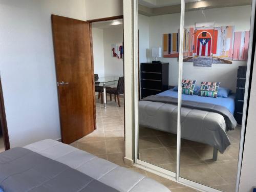 sypialnia z lustrem, łóżkiem i stołem w obiekcie Vistas De San Juan One Bedroom One Bath 303 Apt w mieście San Juan