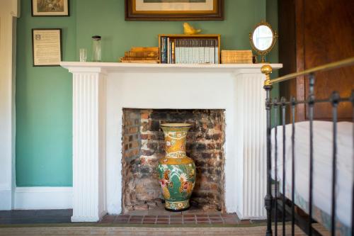 a fireplace with a vase sitting on top of it at Roundwood House in Mountrath