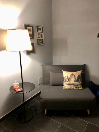 a living room with a couch and a lamp at B&B CAMPITELLO 13 di Caterina Costan in San Nicolò di Comelico