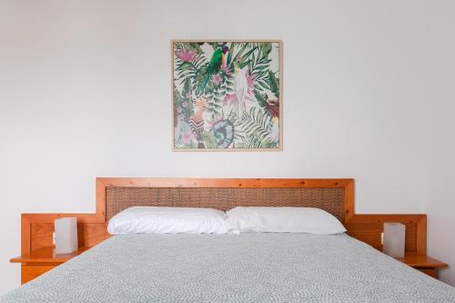 科斯塔特吉塞DARUMA APARTMENTS 2-Bedroom Duplex with Sea Views的卧室里的一张床，墙上挂着一幅画
