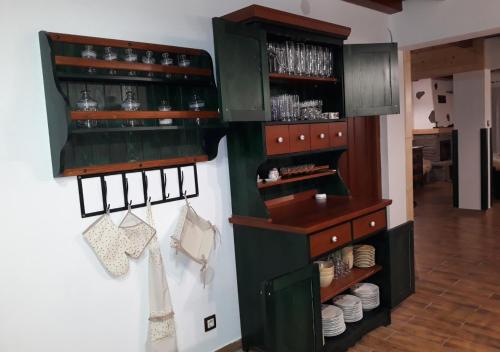 a kitchen with green cabinets and plates on a wall at Csendes Bükk 2 Kulcsosház in Izvoare