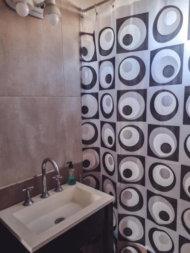 a bathroom with a sink and a shower curtain at Duplex 571 in Chascomús