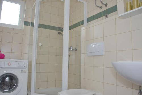 a bathroom with a washing machine and a sink at SunShine in Novalja