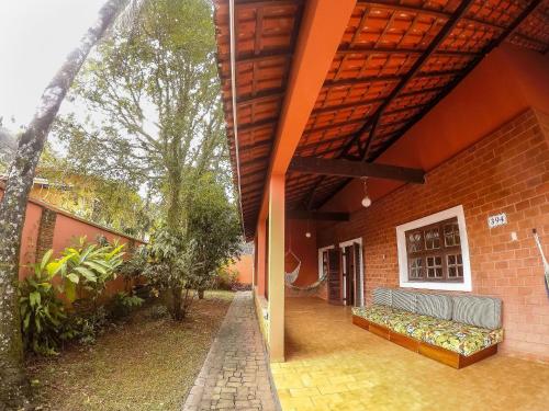 an outdoor patio with a couch on a brick building at Casa com piscina a 350m da praia em Boiçucanga in Boicucanga