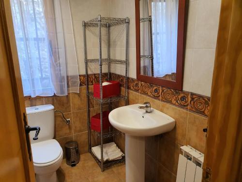 a bathroom with a sink and a toilet and a mirror at HOTEL MASIA EL MOLINETE in Mora de Rubielos