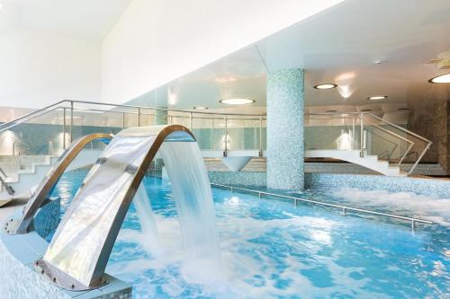 a indoor swimming pool with a water slide at Family & Business Sauna Tężnia Apartments No12 Leśny nad Zalewem Cedzyna - 1 Bedroom with Private Sauna, Bath with Hydromassage , Terrace, Parking, Catering Options in Kielce