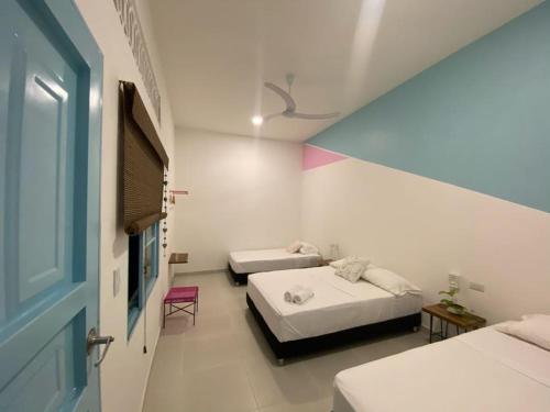 a bedroom with two beds and a blue door at Casa Celeste Honda in Honda