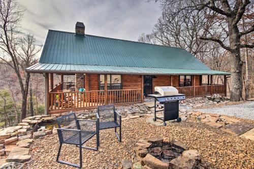a cabin in the woods with a grill and chairs at Enchanting Forested Cabin with Fire Pit and Grill in Sulphur Springs