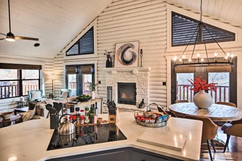 a kitchen and living room with a stove and a fireplace at Enchanting Forested Cabin with Fire Pit and Grill in Sulphur Springs
