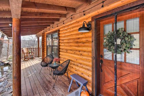a wooden cabin with a door and chairs on a deck at Enchanting Forested Cabin with Fire Pit and Grill in Sulphur Springs