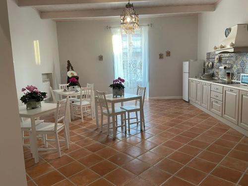 Il comprend une cuisine équipée de tables et de chaises. dans l'établissement B & B La casa dei sogni, à Casapulla