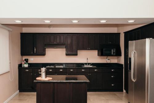 a kitchen with black cabinets and a stainless steel refrigerator at Holiday Inn Durango by IHG in Durango