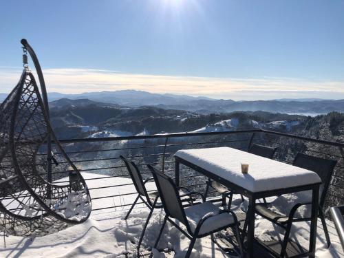 a table and chairs on a balcony with snow on it at Александрова вила 1 in Zlatograd