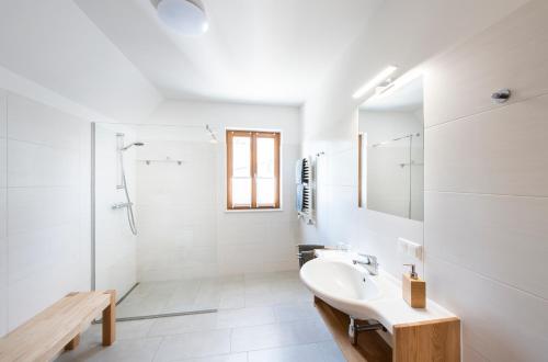 a white bathroom with a sink and a shower at Posthansl l Sernau 1 in Gamlitz