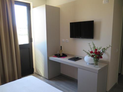 Vaiano Cremasco的住宿－皮尤酒店及汽車旅館，客房设有一张桌子,墙上配有电视。