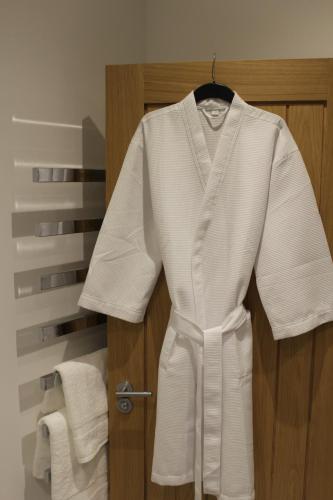 a white robe hanging on a door in a bathroom at Luxury 1 Bed Apartment In The Heart Of Rochester in Wainscot