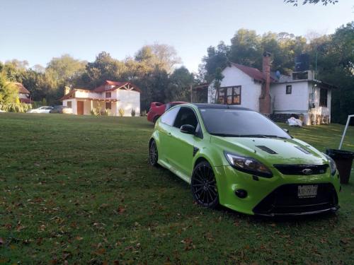 a green car parked in the grass in a yard at Cabañas los cactus 2 in Huasca de Ocampo
