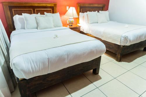 a hotel room with two beds and a lamp at Casa Graciela Hotel Pátzcuaro in Pátzcuaro