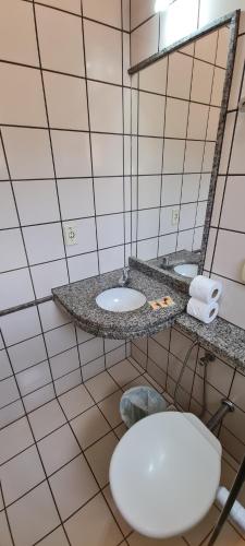 a bathroom with two sinks and a toilet in it at diRoma Fiori - Apartamentos JN in Caldas Novas