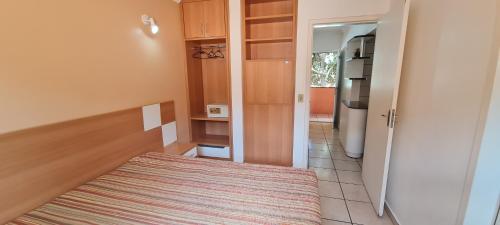 a small room with a bed and a kitchen at diRoma Fiori - Apartamentos JN in Caldas Novas