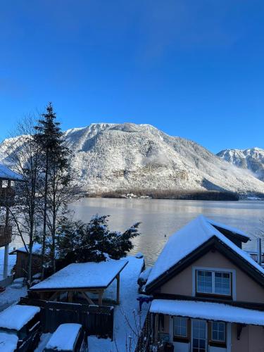 a house covered in snow with a mountain in the background at Appartement Emilia in Hallstatt