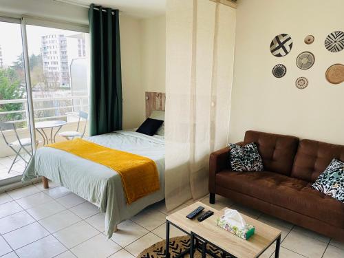 a bedroom with a bed and a couch at Spacieux studio sans vis à vis in Chelles