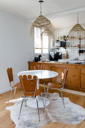 - une cuisine avec une table et des chaises blanches dans l'établissement Magnifique appartement 50m2 aux portes de Nantes, à Vertou
