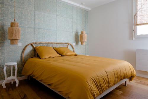 une chambre avec un lit avec un couvre-lit jaune dans l'établissement Magnifique appartement 50m2 aux portes de Nantes, à Vertou