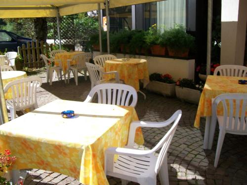 an outdoor patio with tables and chairs with yellow and white tables at Albergo Bellavista in Castello Tesino