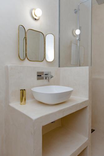une salle de bain avec un lavabo blanc et deux miroirs dans l'établissement Magnifique appartement 50m2 aux portes de Nantes, à Vertou