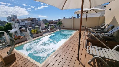 a swimming pool on a balcony with an umbrella at Fierro Hotel Buenos Aires in Buenos Aires