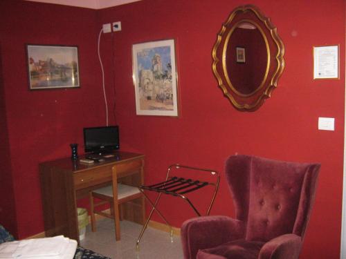 ローマにあるホテル フェラーロのデスク、椅子、鏡が備わる客室です。