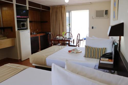 a hotel room with a bed and a kitchen at Alba Suites Acapulco in Acapulco