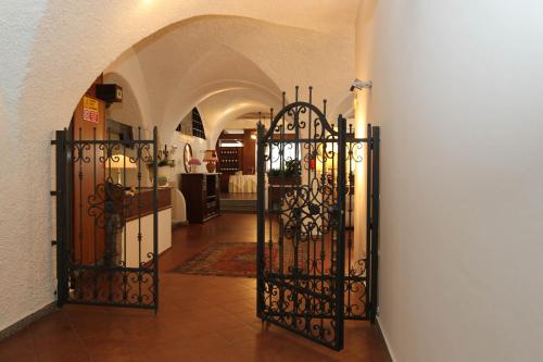 an archway with a gate in a building at Olympic Turismo Antico Borgo Hotel in Spiazzo
