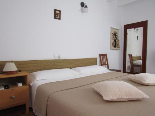 um quarto com uma cama grande com duas almofadas em VIVIENDAS TURISTICAS CAN MARIANO BARBER - ES CALÓ - FORMENTERA em Es Calo