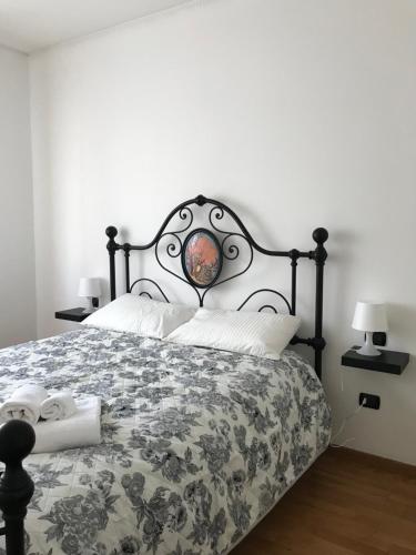 a bedroom with a bed with a black and white bedspread at MGM HOME AREZZO in Arezzo