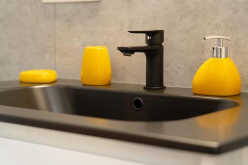 a black sink with two yellow soap dispensers at Open Source à l'entrée du Circuit! in Stavelot