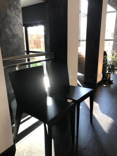 a black chair sitting in the middle of a room at La Suite Cosy - Votre Pause Arborée in La Bruyère
