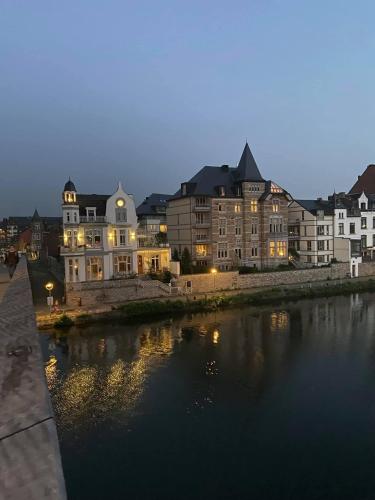 a group of buildings next to a river at night at La Suite Cosy - Votre Pause Arborée in La Bruyère